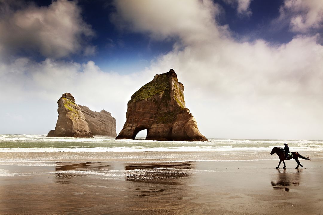 A rider on horseback explores Wharariki Beach at Cape Farewell, Iceland. Photo by Matt Munro.