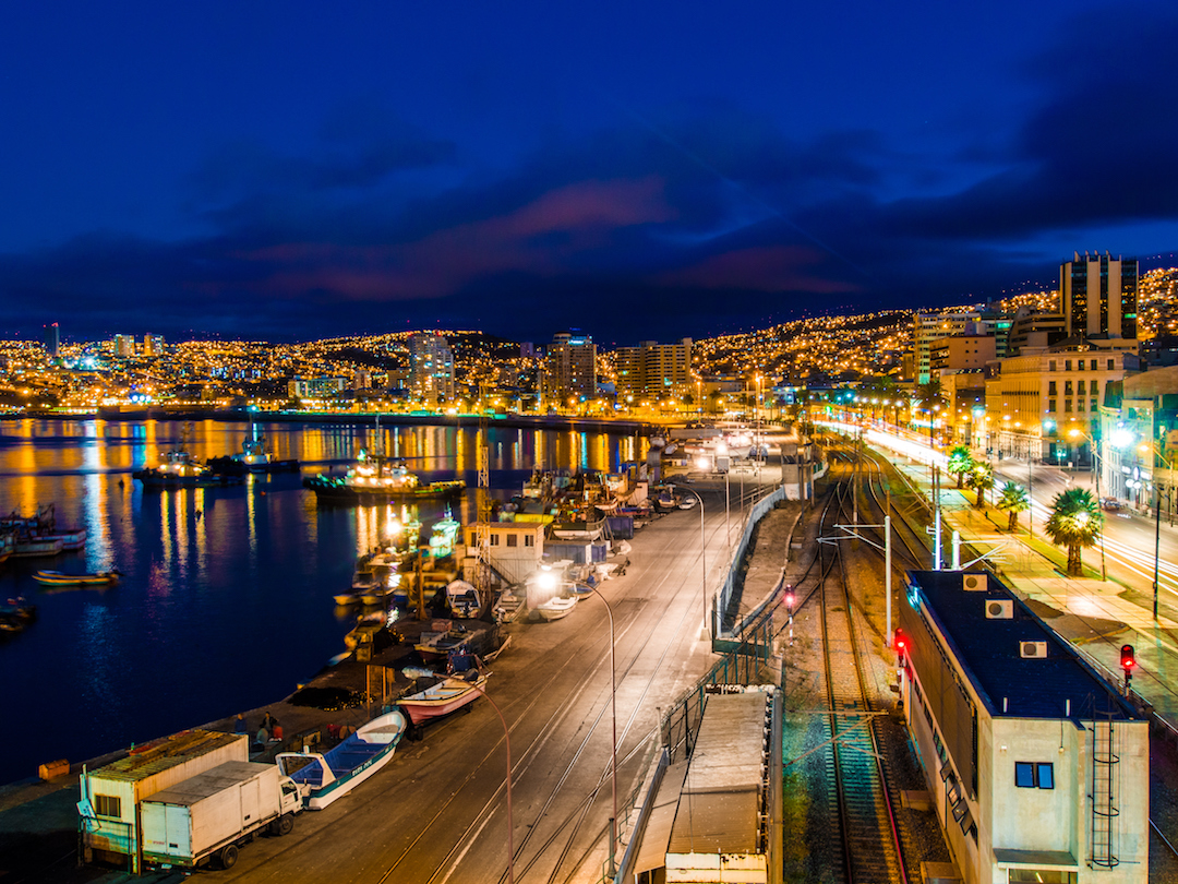 City lights illuminating the surrounding waters by the port in Valparaiso, Chile at night.