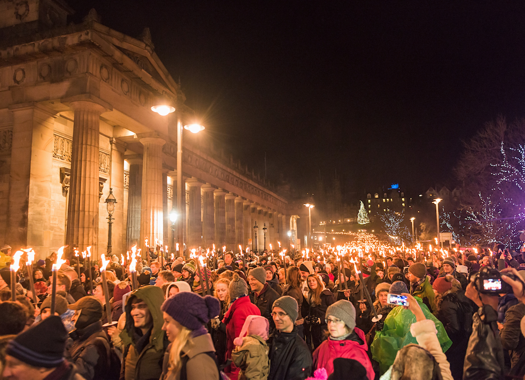 Participants in Edinburgh's annual torchlight night procession coming down The Mound in the city centre.