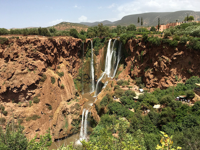 A view of the Ouzoud Falls water cascading through brick red slopes