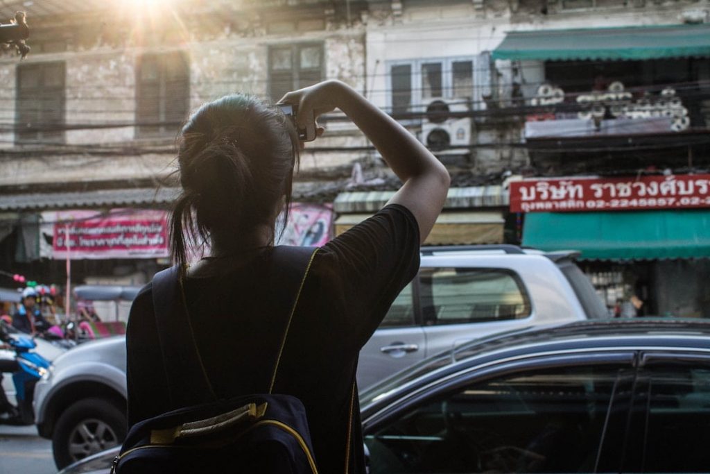 a woman takes a picture of a series of storefronts