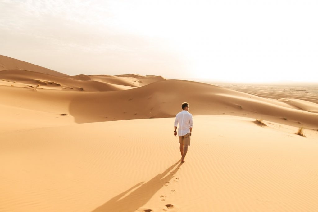 man walking in a the Sahara desert