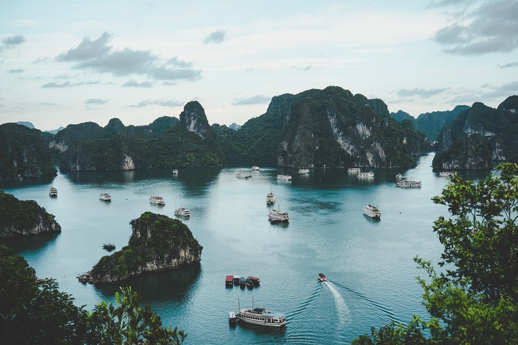 Aerial view of Ha Long Bay with junk boats sailing through the limestone pillars