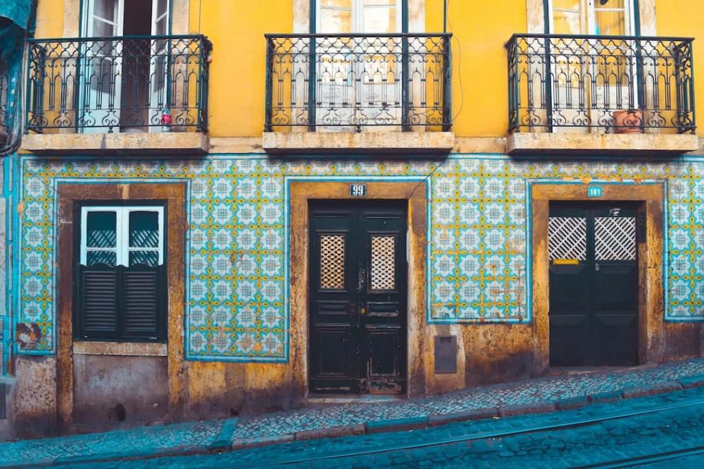 A door on a bright yellow building in Lisbon, Portugal