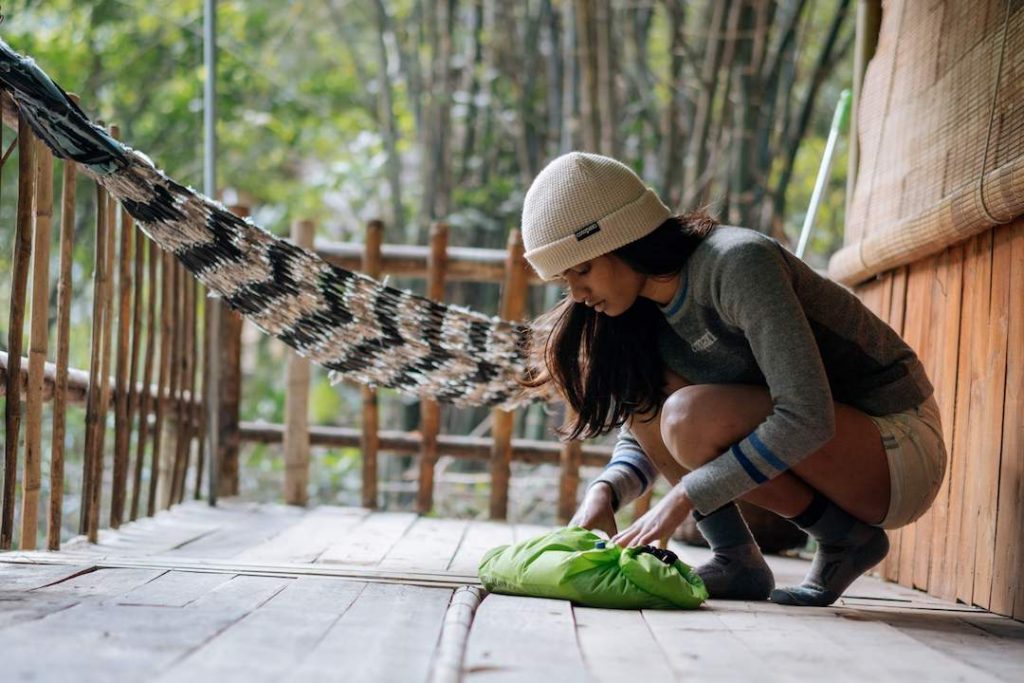 Young female traveller washes her clothes with The Scrubba while on the go