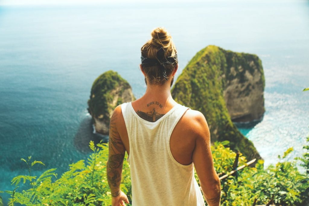 tattooed man on a cliff- flying with a new tattoo