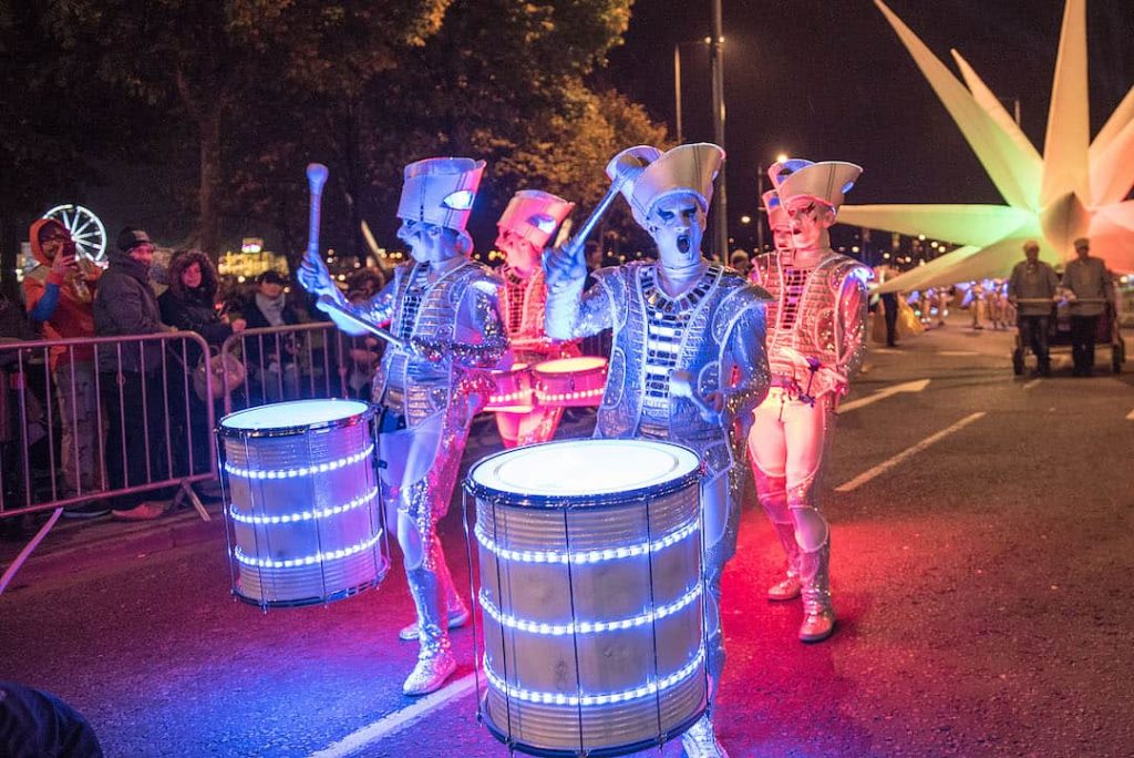 Four people in a costume beating drums participating in a street parade in Derry for Halloween
