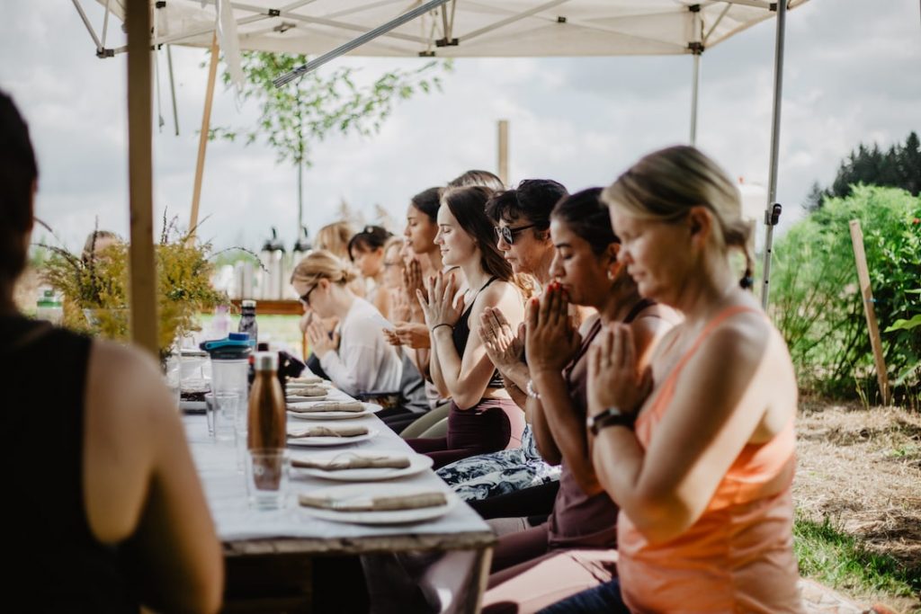 A yoga community gathers for a meal at the Heart Mindfulness Retreat by Kind Yoga