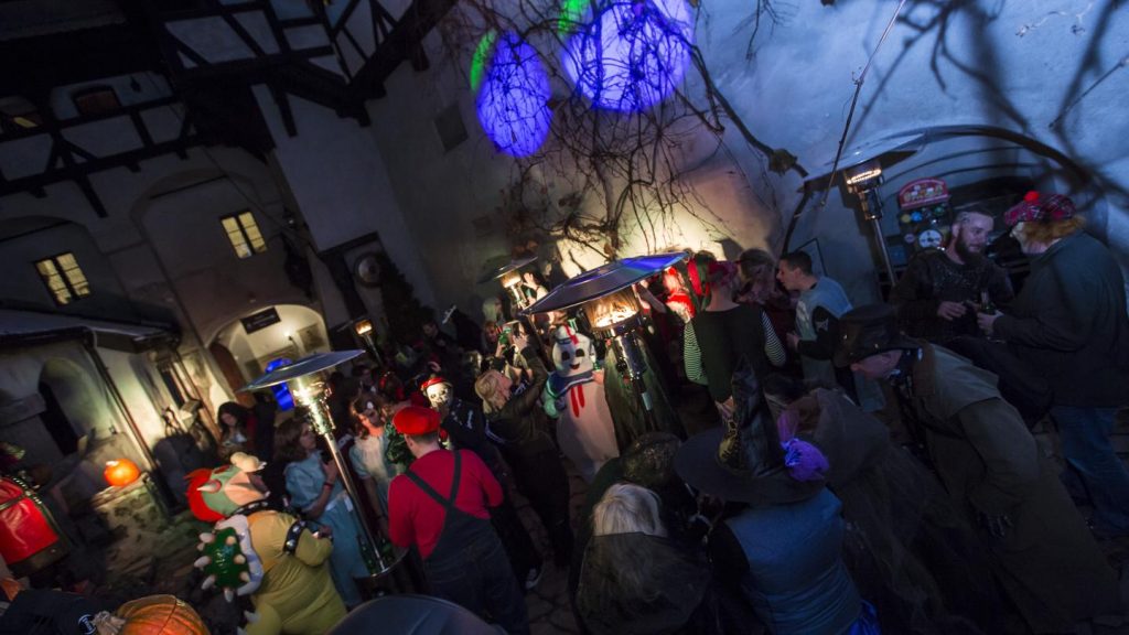 People wearing costumes in a courtyard party at Bran Castle in Romania