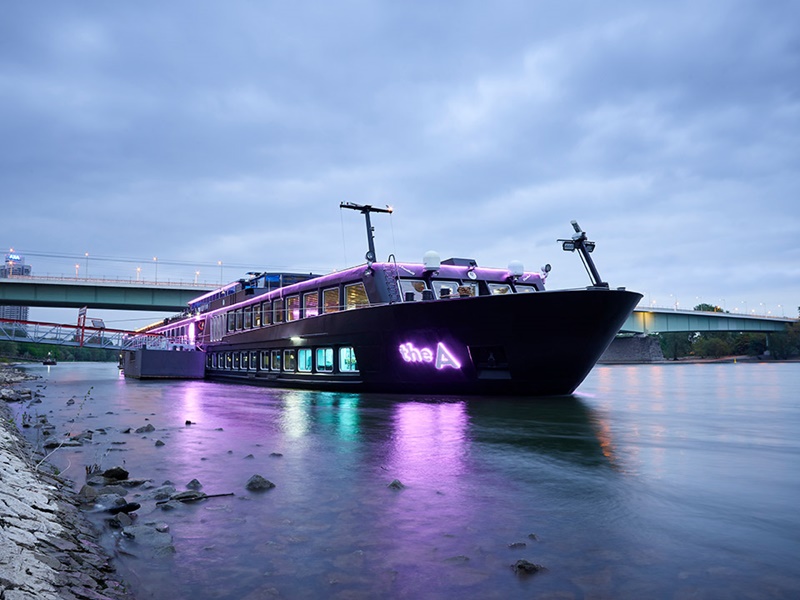 U by Uniworld sleek black river cruise ship sailing down a river