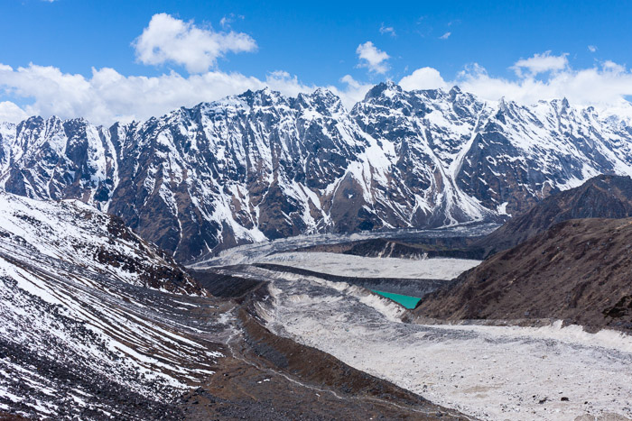 a turquoise waterbody sits in a valley of the Manaslu Circuit