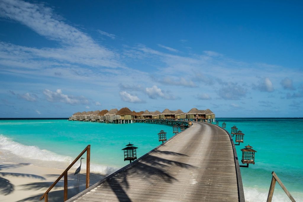 a long dock stretching into turquoise water in the Maldives