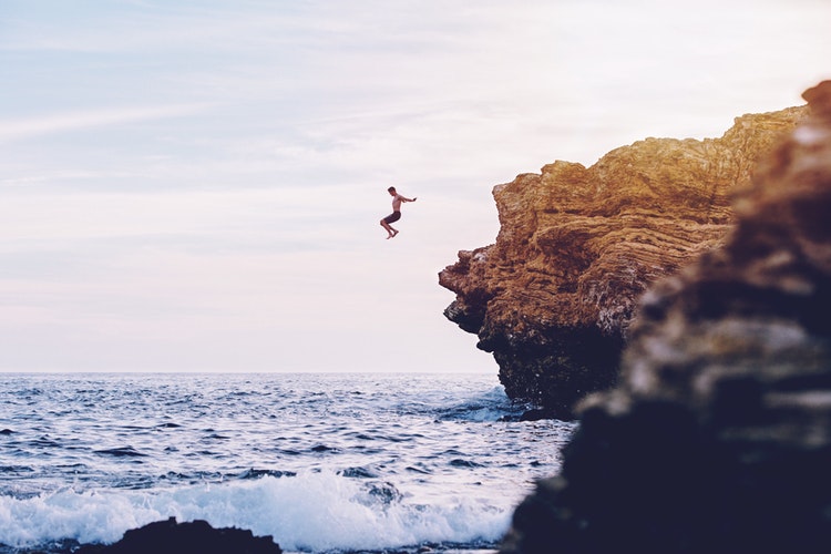 Is Travelling Solo Fun: Man cliff dives into the sea