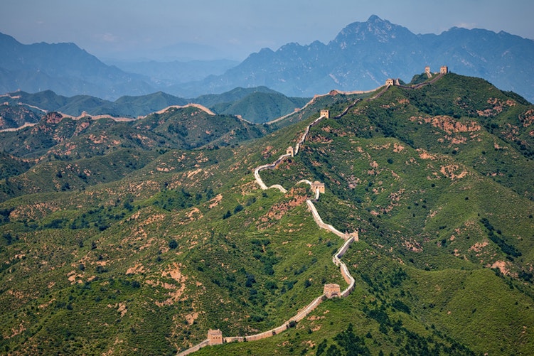 Aerial view of the Great Wall of China and surrounding green pastures