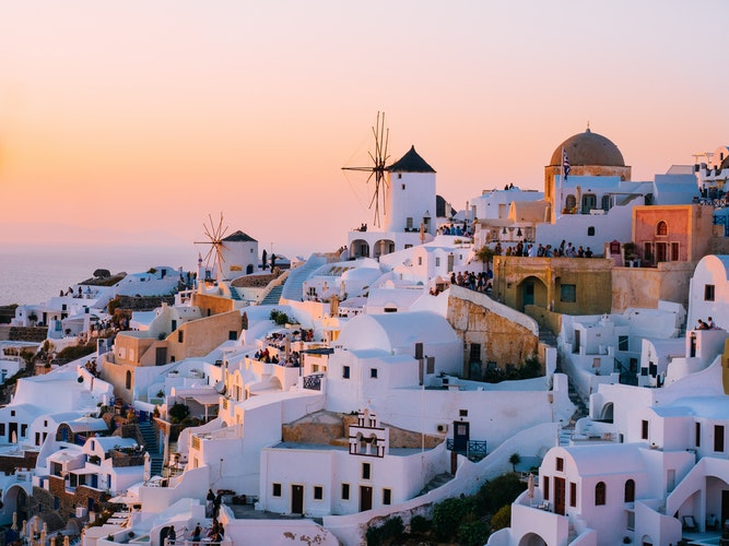 An orange sky at sunset over the white city of Santorini