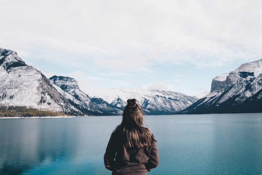 A girl stands by Lake Minnewanka, Alberta
