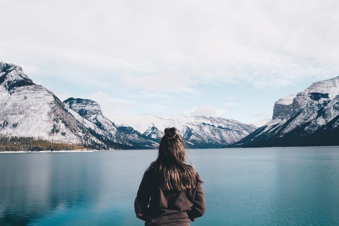 A girl stands by Lake Minnewanka, Alberta