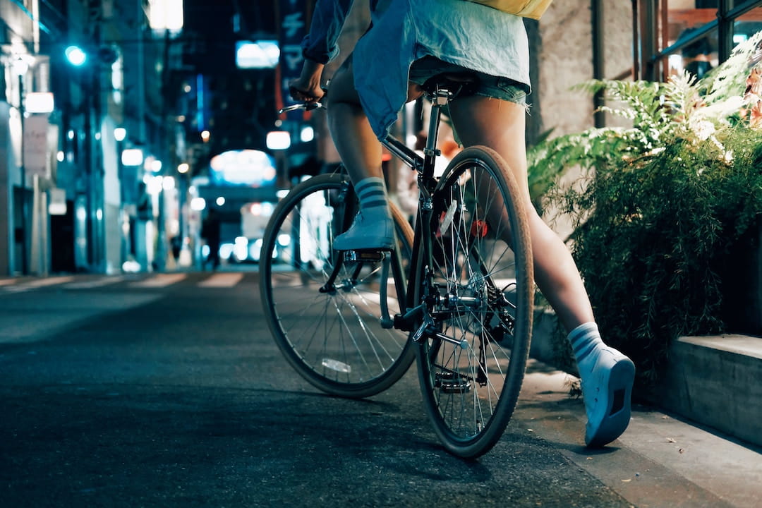 a person kicking off a bike on a busy city street at night