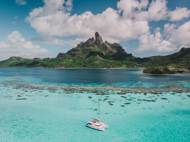 aerial view photo of boat on body of water and a view of mountain