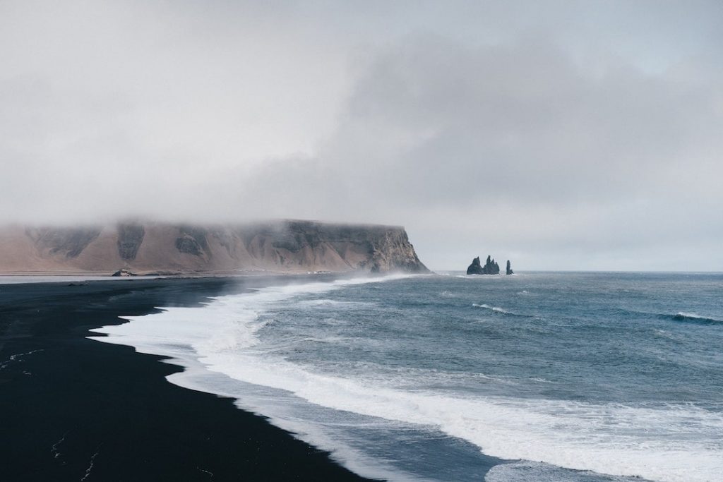 A black sand beach in Vik, Iceland on a foggy day