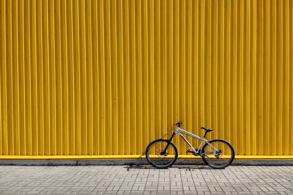 A bike sits against a yellow wall