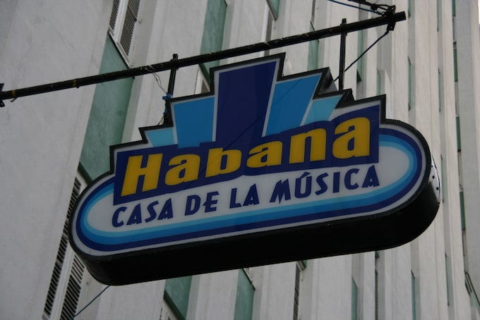 A blue and yellow sign in Havana that says "Habana Casa De La Musica"