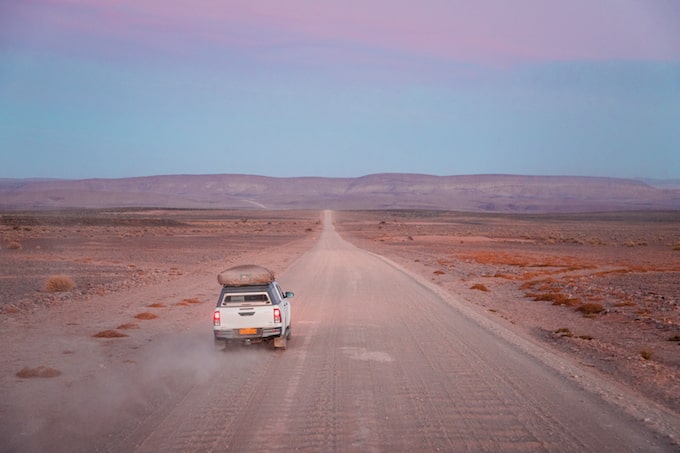 A car driving down a dirty road towards Fish River Canyon, Namibia
