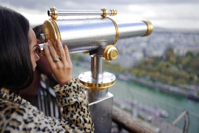 A woman looking through a telescope in Paris