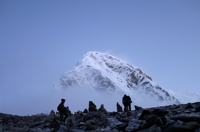 A group of people sitting near Mount Everest on a foggy day
