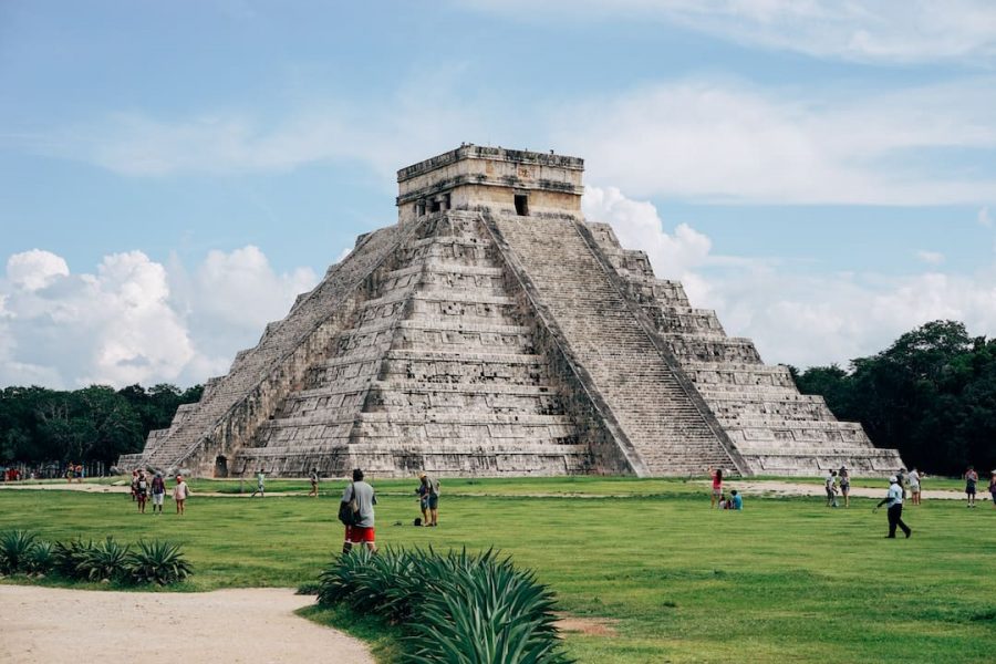 Chichen Itza temple with a few people nearby and blue skies