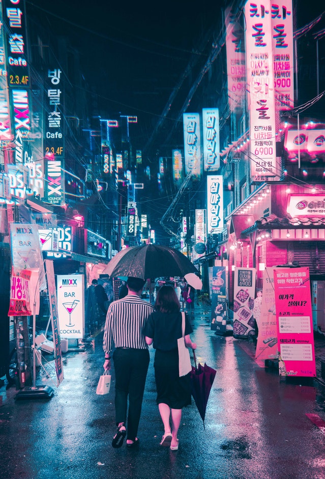 man holding umbrella beside woman while walking on street