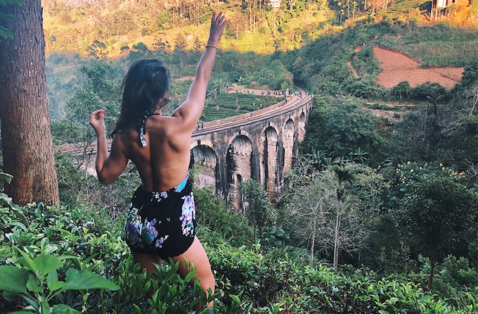 a girl with her arm up waves across the landscape