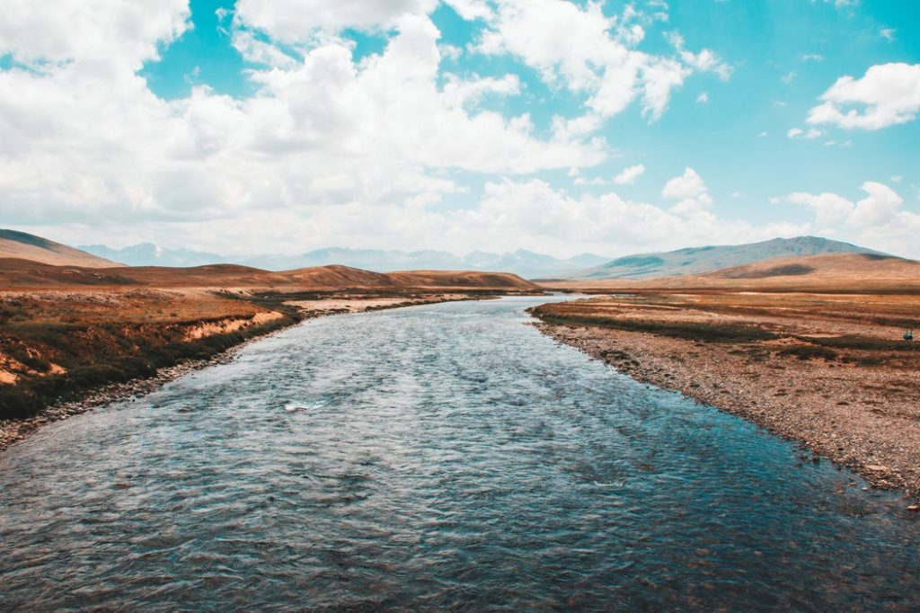 deosai plains: a waterbody snakes through brown riverbanks