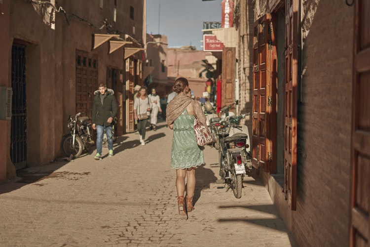 a women walking a dusty cobbled street in Marrakech