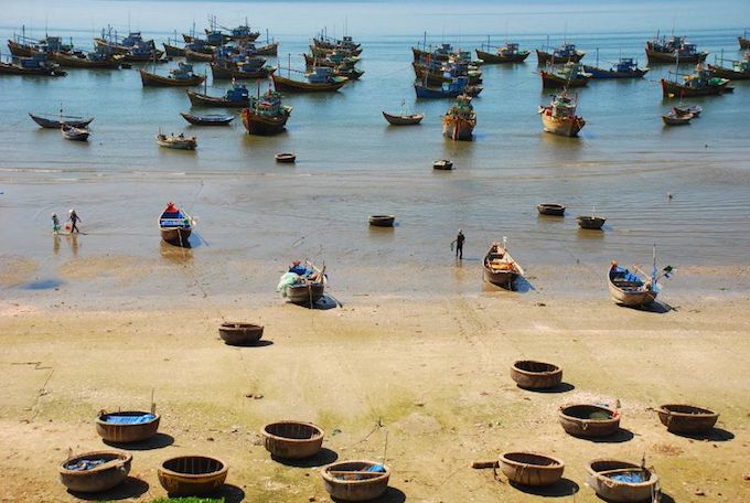 Traditional round boats floating in the sea at Mui Ne beach