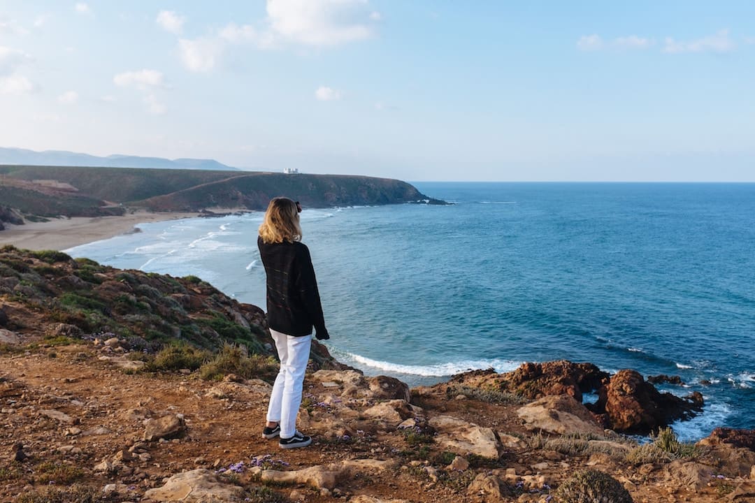 A woman standing looking out onto the ocean in Morocco