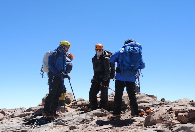 A group of three people climbing Mount Kilimanjaro