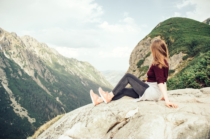 a woman sitting on a mountain