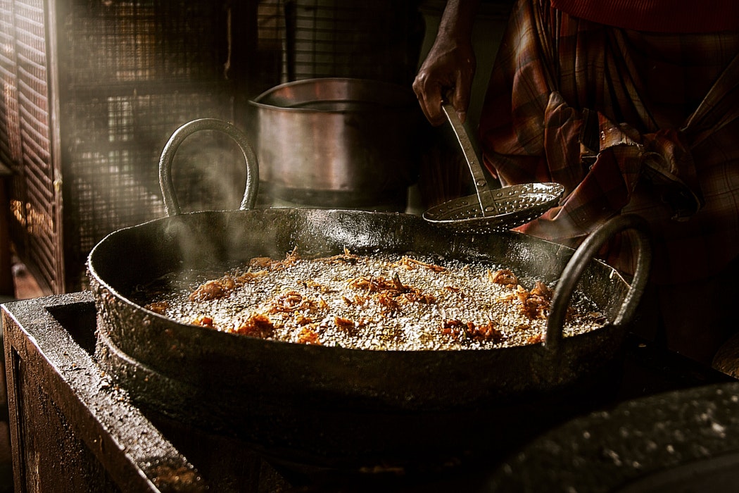 a large steaming pot of food is being dished out with a ladle