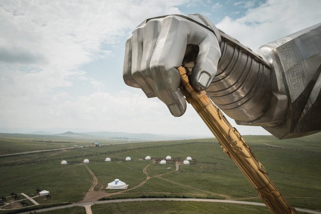 The arm of the Genghis Khan Statue Complex with a ger camp in the background in Tsonjin Boldog, Mongolia