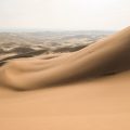 Two people standing on top of Khongoryn Els in the Gobi Desert, Mongolia