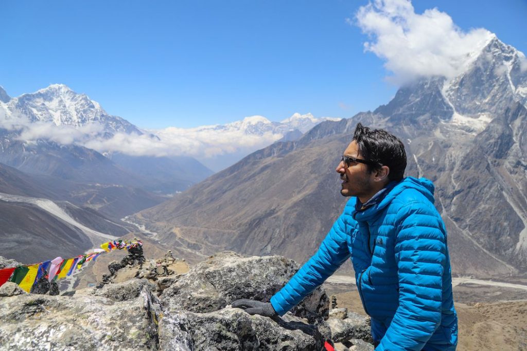 a man looking out at a valley across the mountains