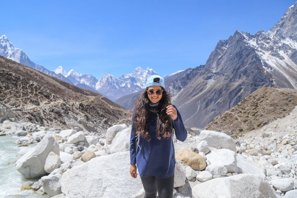 a girl in a blue cap in a mountain valley smiling