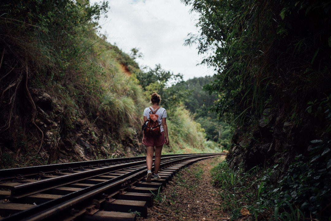 A girl walking alone on train tracks in Sri Lanka