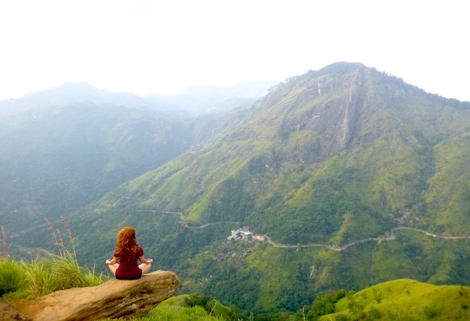 A woman sitting on the edge of a cliff in Ella, Sri Lanka