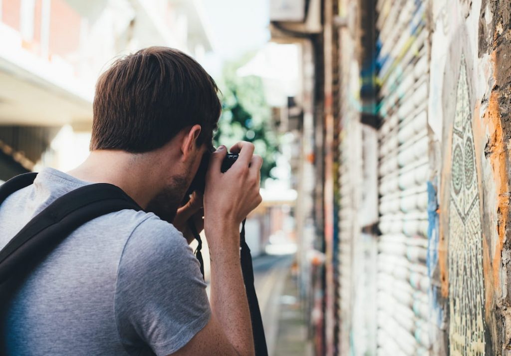 Man holding camera and taking photos on the street