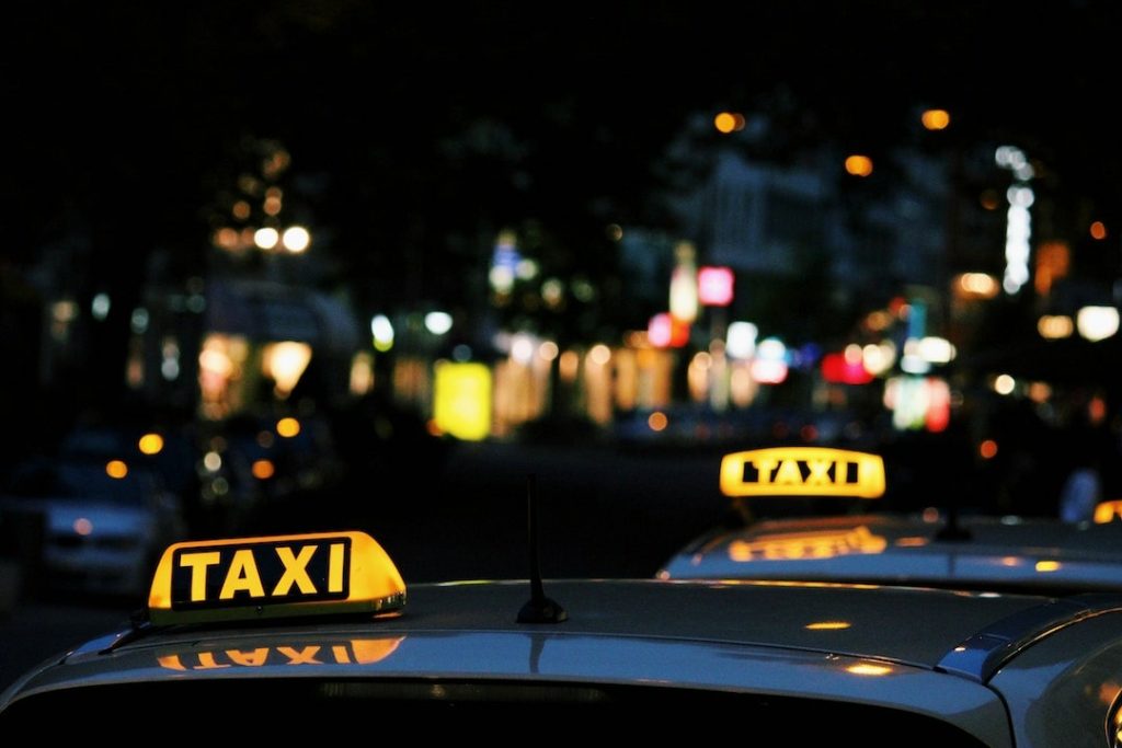 Two taxis parked next to each other at night