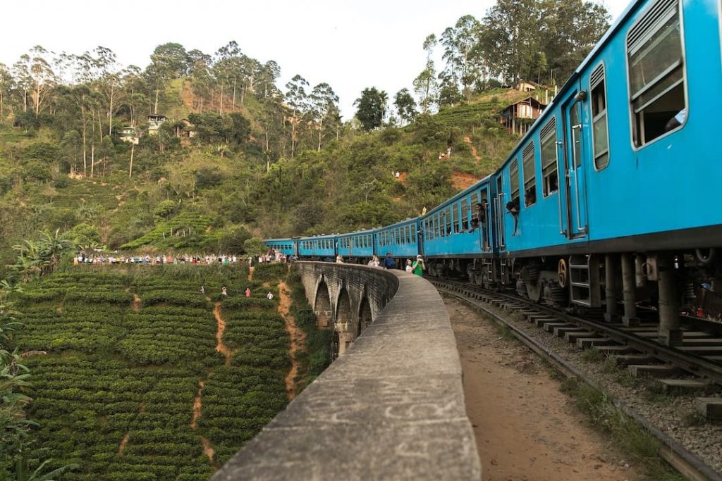 Blue train crossing over Nine Arch Bridge in Ella, Sri Lanka