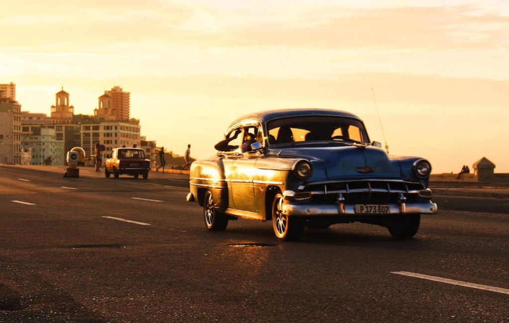Vintage car driving the road at sunset in Havana, Cuba