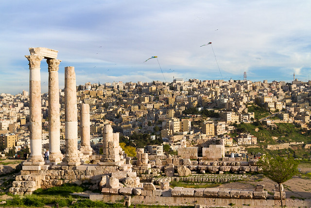 stone ruins and pillars with a city in the backgrou